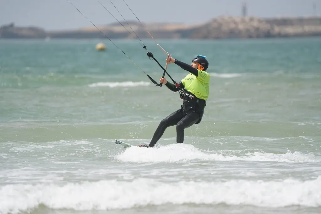 Rider in a yellow vest carving through the waves