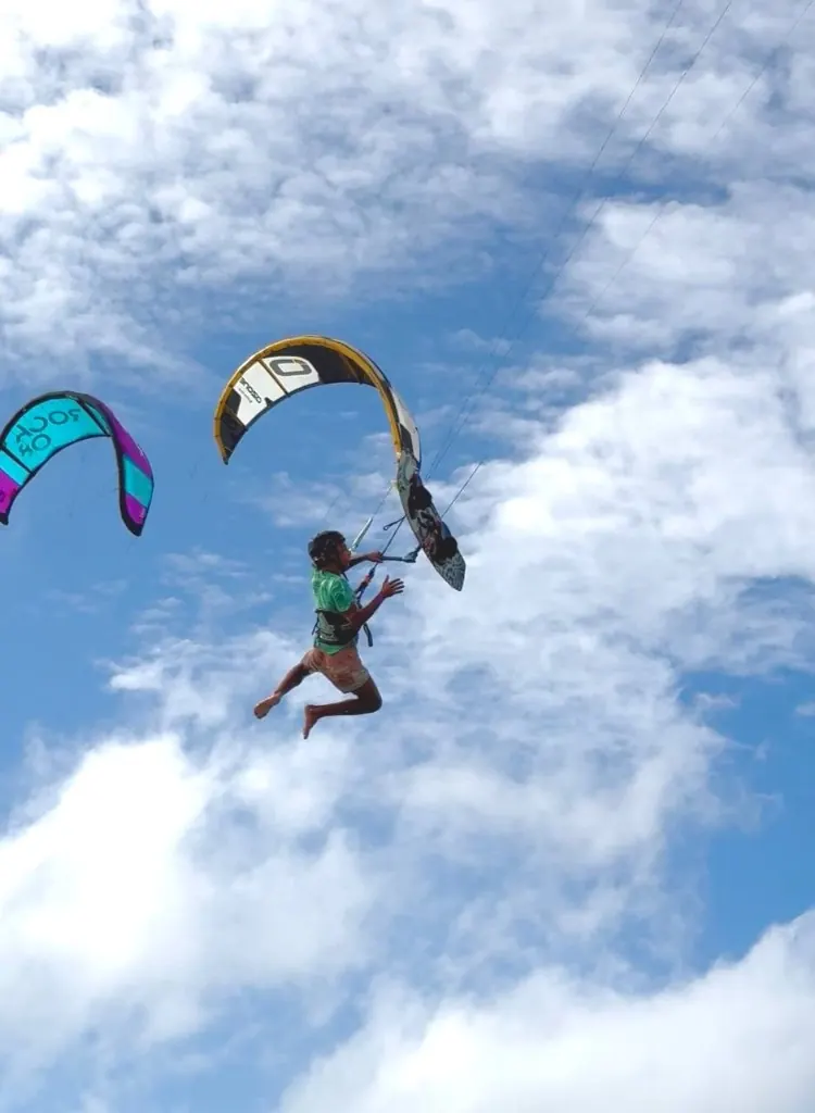 Rider jumping with the board off under a kite